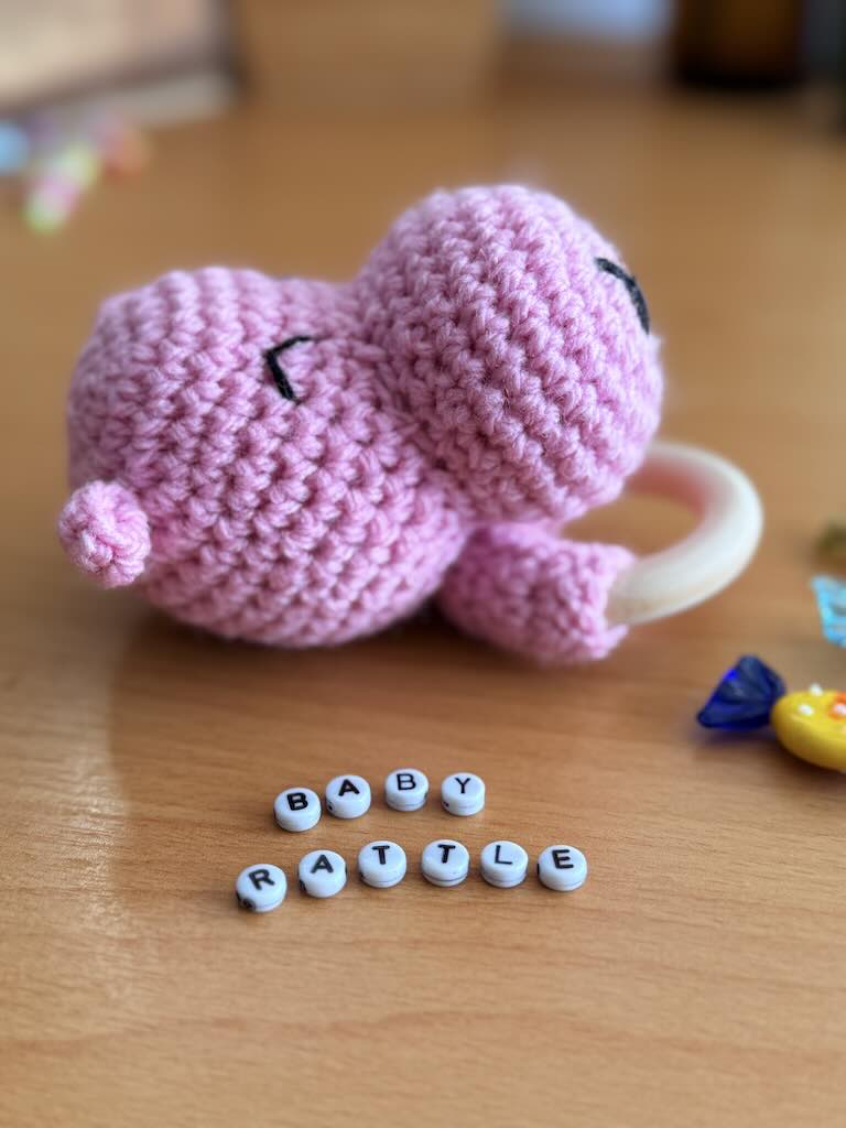 cute handmade crochet pink hippo rattle with friendly face and soft texture