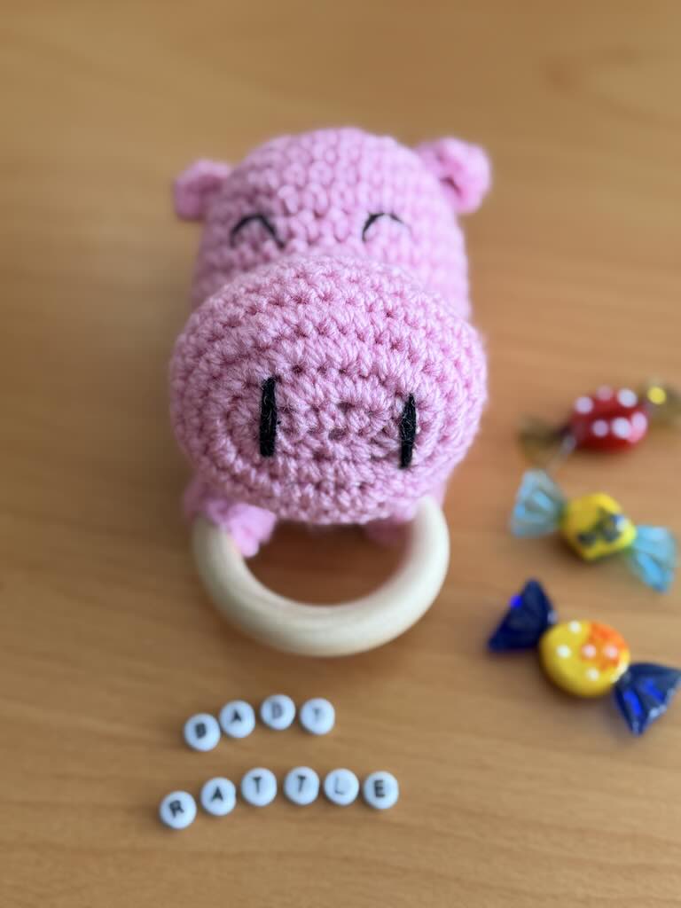 cute handmade crochet pink hippo rattle with friendly face and soft texture