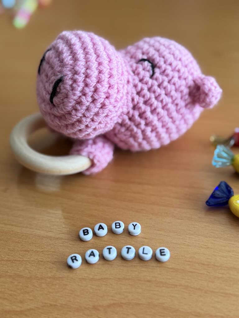 cute handmade crochet pink hippo rattle with friendly face and soft texture