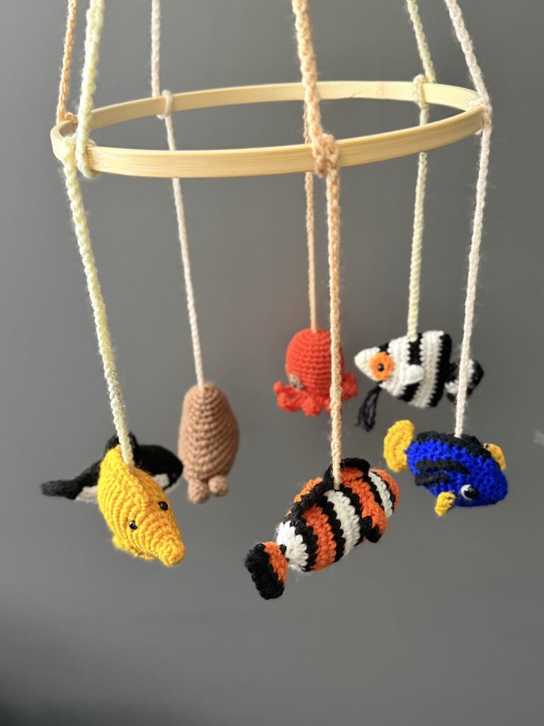 handmade crochet baby mobile featuring whales, seals, fish, and octopus toys