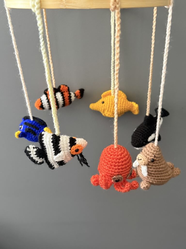 handmade crochet baby mobile featuring whales, seals, fish, and octopus toys