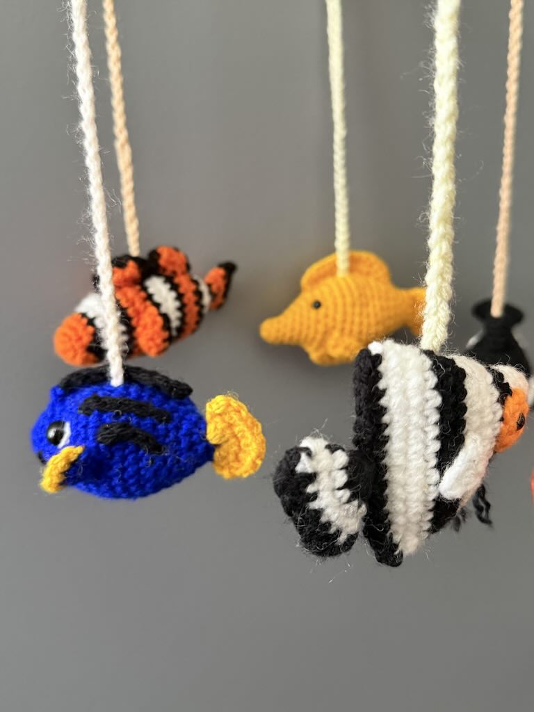 handmade crochet baby mobile featuring whales, seals, fish, and octopus toys