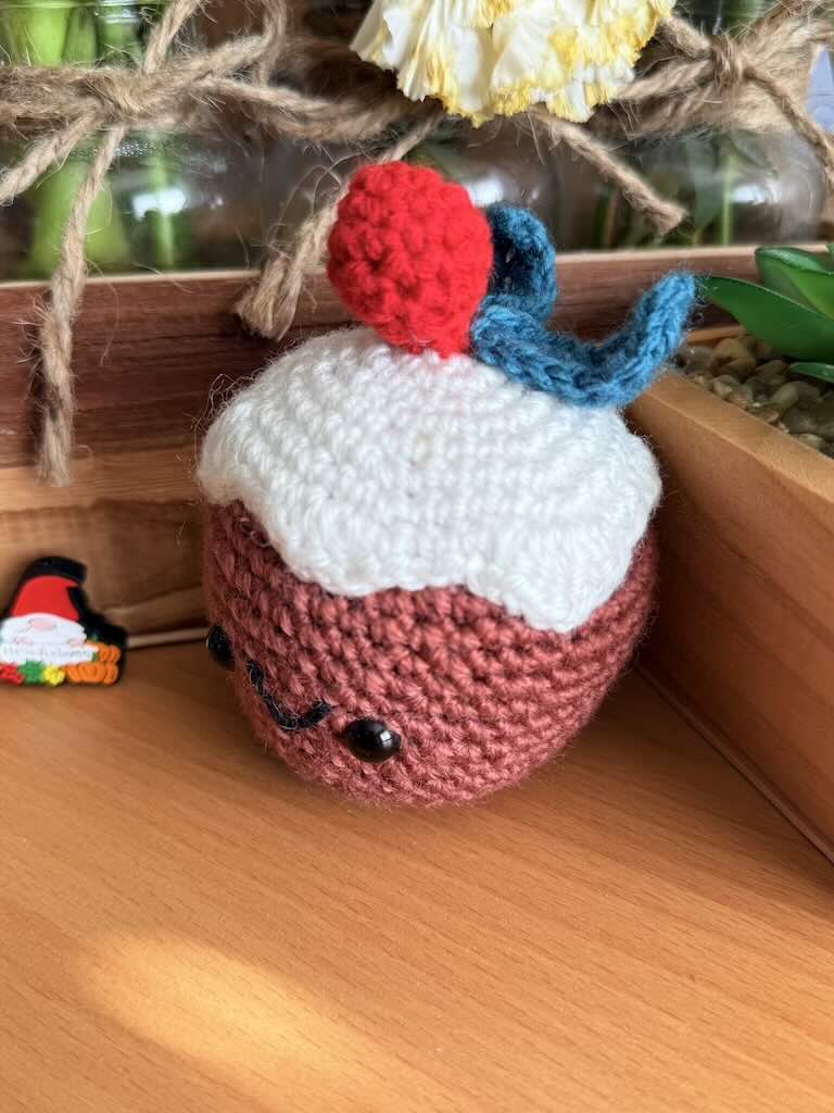 crochet christmas cake toy with festive decorations and colorful yarn