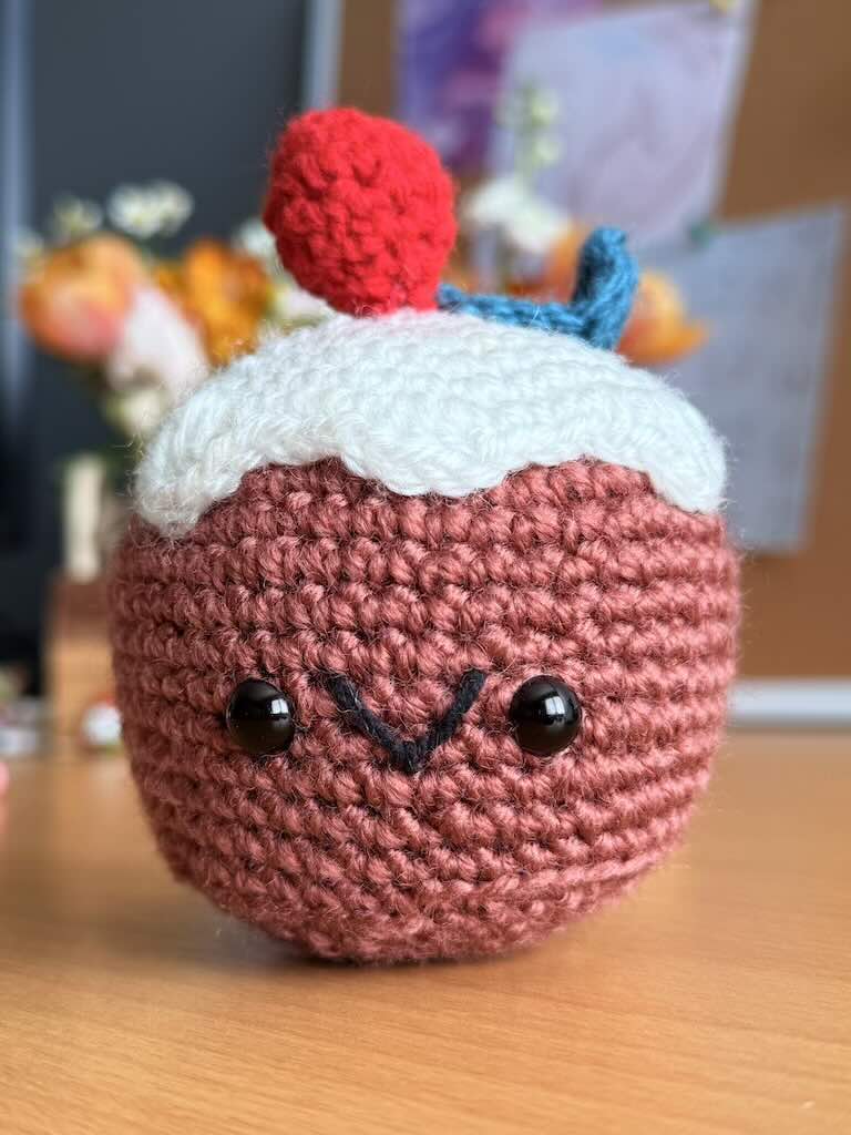 crochet christmas cake toy with festive decorations and colorful yarn