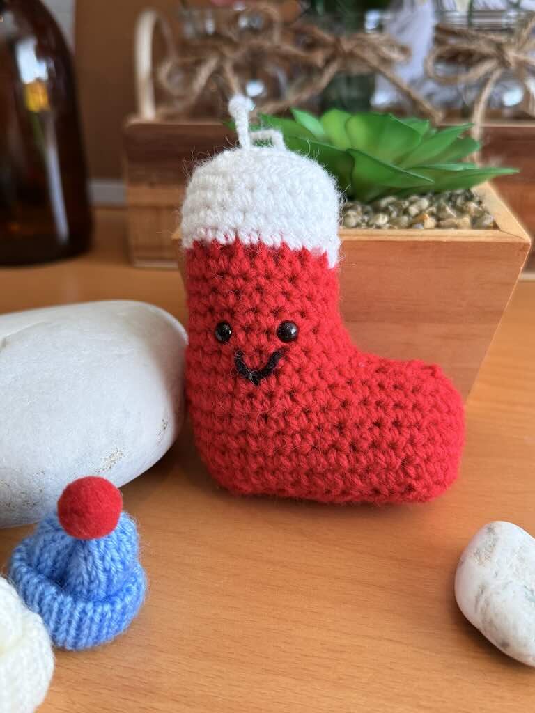 handmade crochet Christmas stocking in red and white with festive details