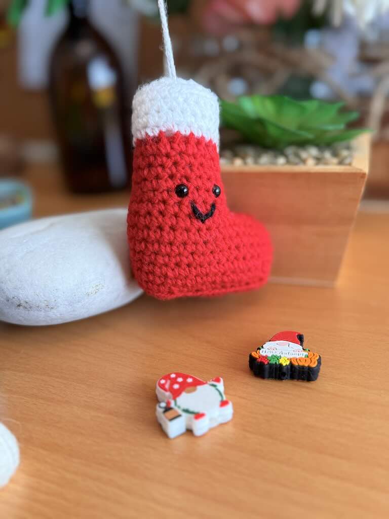 handmade crochet Christmas stocking in red and white with festive details