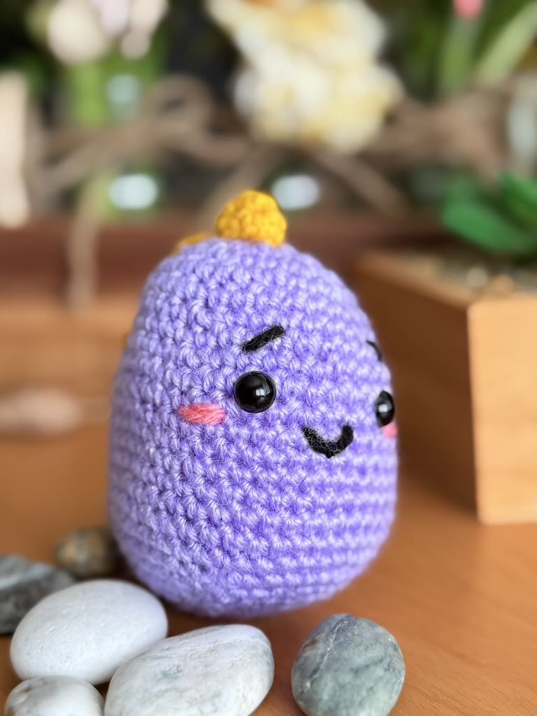 handmade crochet purple baby dragon with yellow scales and friendly smile