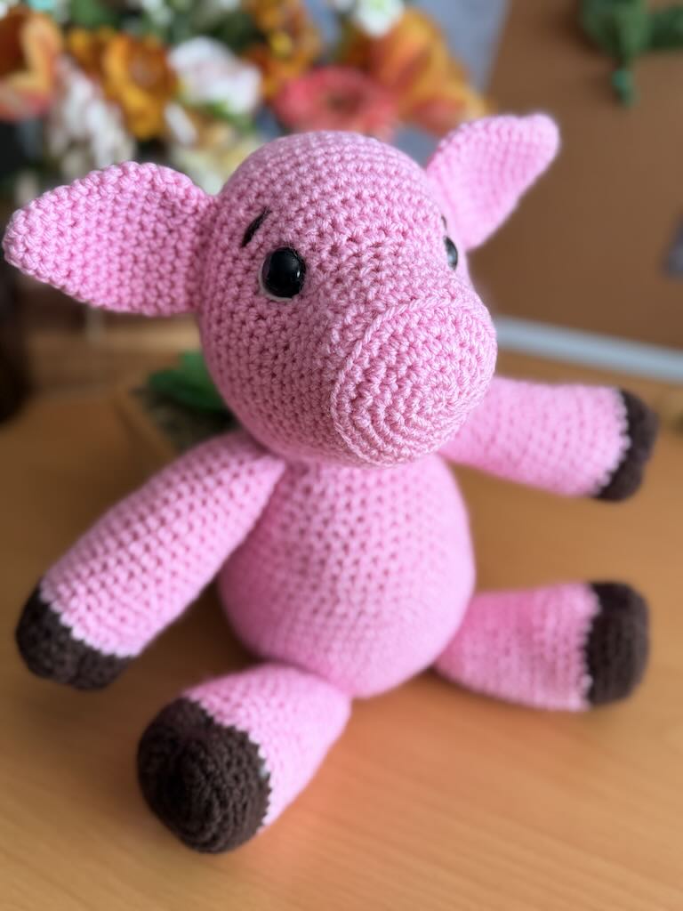 cute handmade crochet pink piggy with round body and friendly face