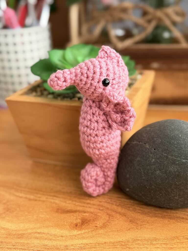 handmade crochet seahorse toy named Saul with curly tail and delicate pink fins