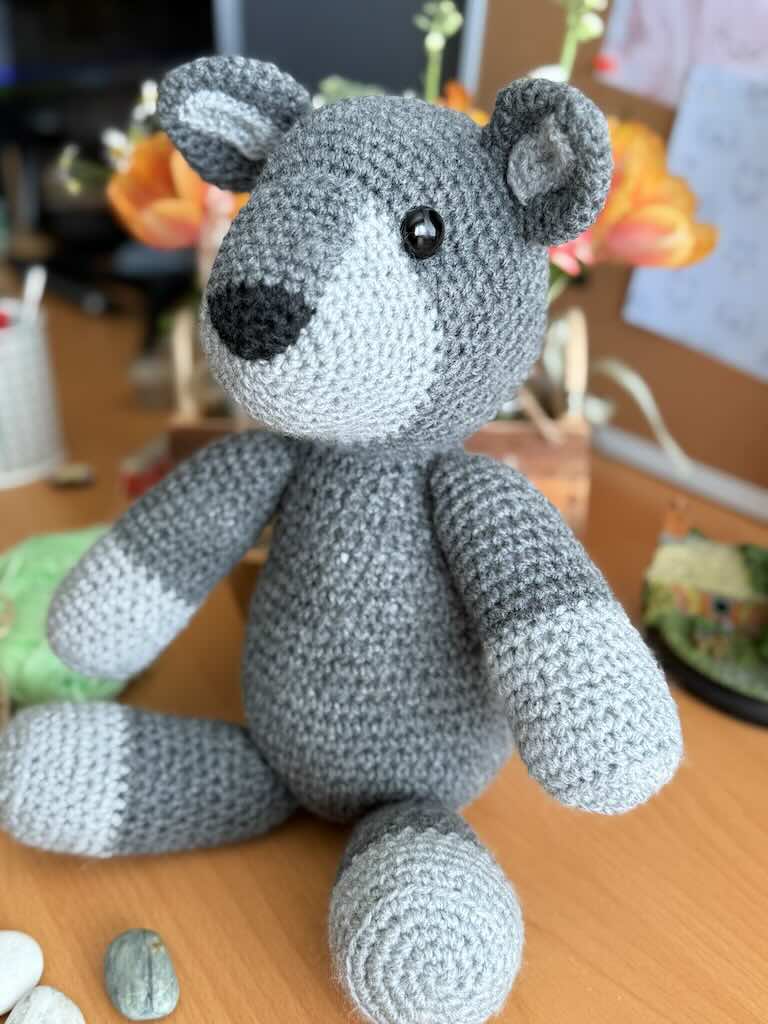 handmade crochet fox toy named Felix with a bright grey body and bushy tail