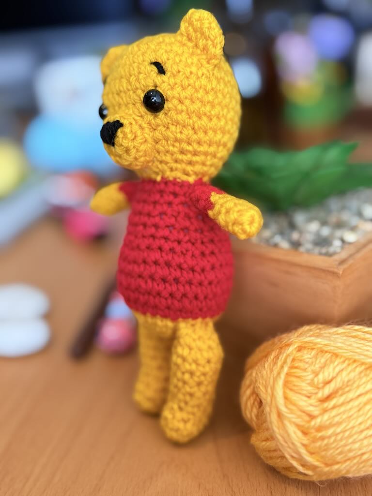handmade crochet bear toy inspired by Winnie the Pooh with red shirt and warm smile