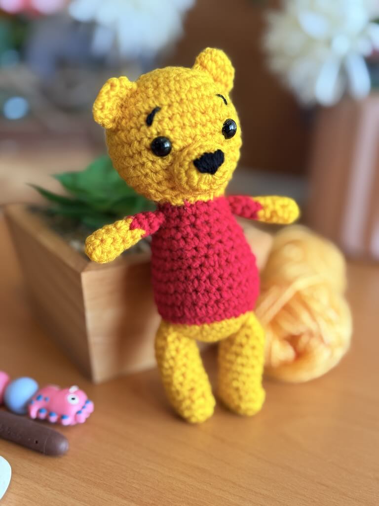 handmade crochet bear toy inspired by Winnie the Pooh with red shirt and warm smile